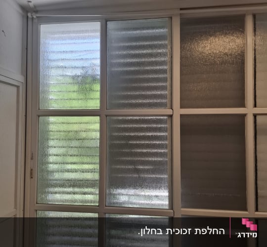 חלון זכוכית עם מסגרת לבנה